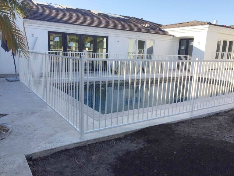 White iron pool fence surrounding a swimming pool in San Diego