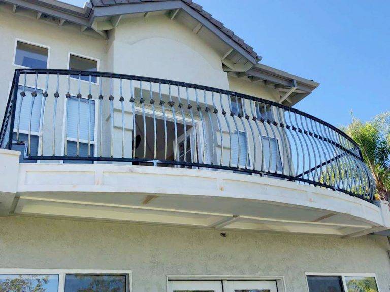 Curved iron balcony railing on a two-story San Diego home