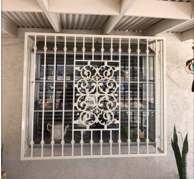 Decorative iron window guard fitted over a San Diego home window