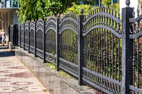 Arched scroll-panel black wrought iron fence at a San Diego residence