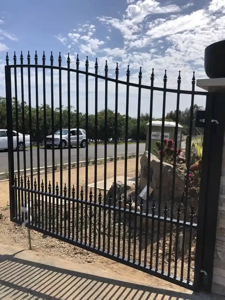 Black wrought iron automatic single swing driveway gate standing open in Oceanside